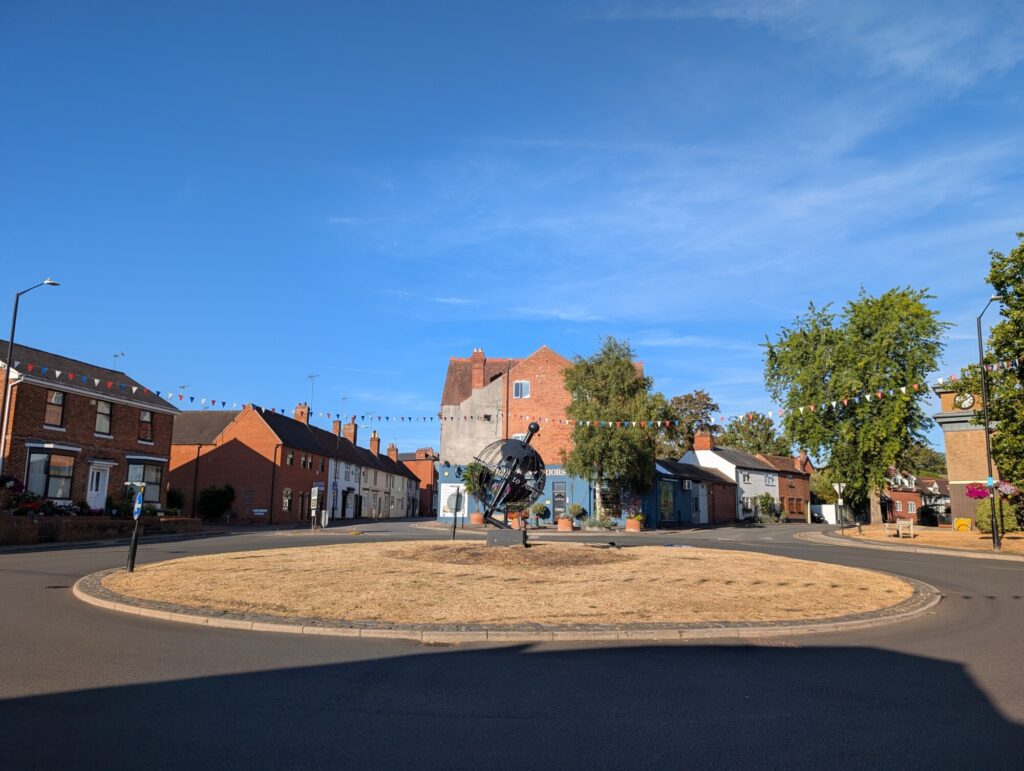 The Globe Roundabout in Alcester on a sunny summer morning, with the Globe sculpture at its centre.