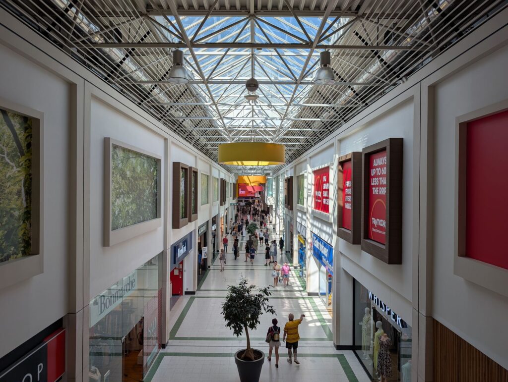 Interior of the Kingfisher Shopping Centre in Redditch, looking along the main shopping mall beneath its glass roof.